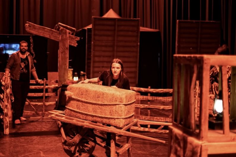 Person hiding behind hay bale